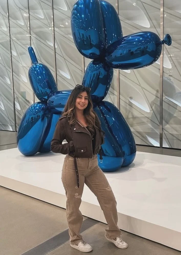 Tatiana Holguin posing in front of a modern sculpture exhibit.
